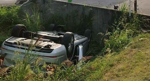 Esce di strada con l'auto e finisce ruote all'aria nel fosso