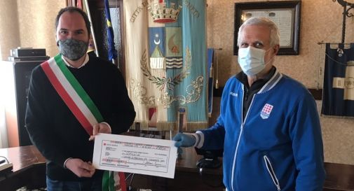 il sindaco mentre riceve la donazione dal rappresentante della Polisportiva Mogliano, il professore Mario Fenso